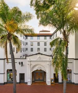 biały budynek z palmami przed nim w obiekcie Hotel Santa Barbara w mieście Santa Barbara