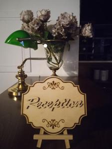 un jarrón de flores en una mesa con un cartel en Αρχοντικό Ταξίμι (Μουντζουρίδη), en Argalasti