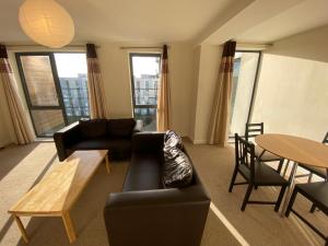 a living room with a couch and a table at Rooms in exquisite and centrally located apartment in Colindale