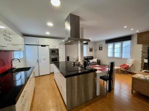 a kitchen with white cabinets and a black counter top at Zayas enea in Elizondo