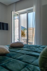 a bedroom with a large bed with a large window at Alloggio nuovissimo al centro e rilassante in Ischia