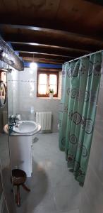 a bathroom with a sink and a shower curtain at Nuestra casa de Luriezo in Cabezón de Liébana