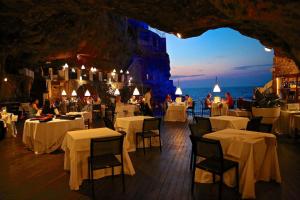 ein Restaurant mit weißen Tischen und Stühlen und Meerblick in der Unterkunft Residenze Unità d'Italia in Bari