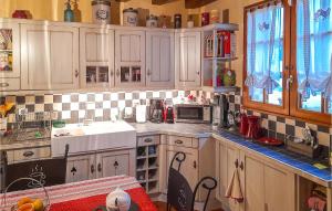 a kitchen with white cabinets and a sink and a microwave at Pet Friendly Home In Salbris With Private Swimming Pool, Can Be Inside Or Outside in Salbris