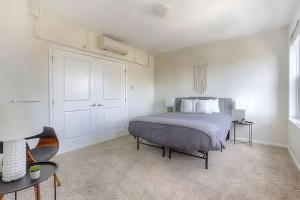 a white bedroom with a bed and a table at Perfect 1BR In Prime Location & View of Stadiums in Detroit