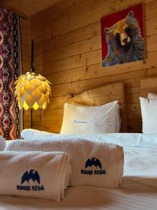 um quarto de hotel com duas camas e uma fotografia de urso na parede em Vysche Neba em Bukovel