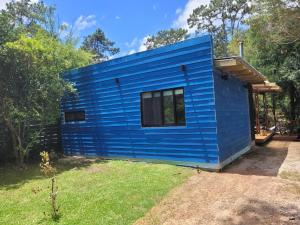 una casa azul con una ventana en un patio en Calma Nativa, en Maldonado