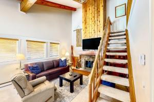 a living room with a staircase and a couch at Big Sky Dreamin in Big Sky