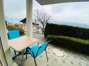 a table and chairs on a patio with a view at Lake View Apartment -14 in Niederried