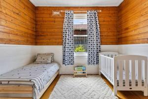 1 dormitorio con 2 camas y ventana en Balmoral Cottage - beach escape, en Kingston Beach