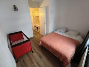 - une petite chambre avec un lit et un placard dans l'établissement T2 Cosy au pied des pistes, à Bagnères-de-Bigorre