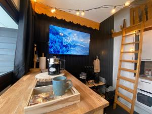 a room with a table with a coffee maker and a tv at Les Menuires centre! Chaleureux studio sur les pistes! in Les Menuires