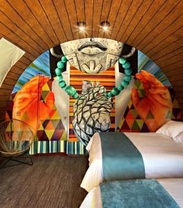 a bedroom with a painting of a head on the wall at Matices Hotel de Barricas in Tequila
