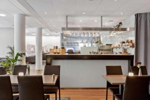 a restaurant with tables and chairs and a counter at Best Western Plus Kalmarsund Hotell in Kalmar
