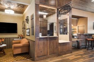 a lobby with a waiting area with a large wooden wall at Best Western Bandera Suites & Saloon in Bandera