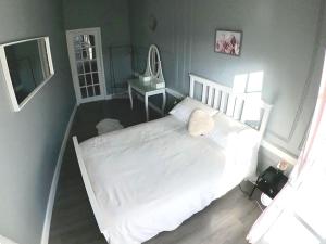 a bedroom with a white bed and a table at Fantastic - Centrally located 1 bed APT with Wi-fi in Dalkeith