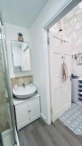 a white bathroom with a sink and a mirror at Fantastic - Centrally located 1 bed APT with Wi-fi in Dalkeith