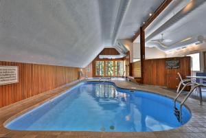 a large swimming pool with blue water in a building at Fall Line Condos by Killington VR - Studios in Killington