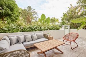 une terrasse avec un canapé, une table et des chaises dans l'établissement Arlo Wynwood Miami, à Miami