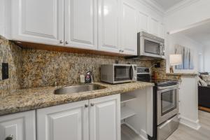 a kitchen with white cabinets and a sink and a microwave at Alani Bay Villas in Fort Lauderdale +70 photos