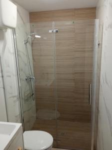 La salle de bains est pourvue d'une douche avec une porte en verre. dans l'établissement Miguel y Rosa 2, à Tíjola