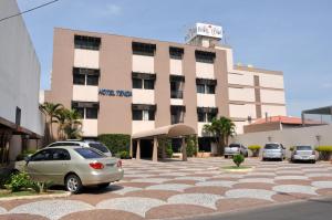 un edificio con coches estacionados en un estacionamiento en Hotel Tenda, en Marília