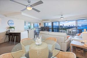 een woonkamer met een bank en een tafel met stoelen bij Gemini Court - Hosted by Burleigh Letting in Gold Coast