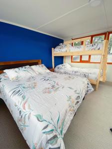 - une chambre avec 2 lits et un mur bleu dans l'établissement Indomito Sur Hostel, à Punta Arenas