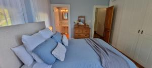 a bedroom with a bed with blue and white pillows at Hill House Hobart - Charming home, stunning views close to city in Hobart