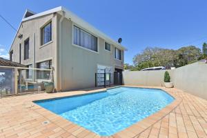 una casa con piscina di fronte a una casa di Baywatch Waterfront Lake Retreat with Private Jetty at Silverwater Lake Macqaurie a Bonnells Bay