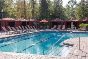 una piscina en un camping con sillas y tiendas de campaña en Tuscana Resort Champions Gate, en Kissimmee