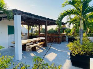 a patio with a wooden picnic table and palm trees at Caribean Vacation Home in Cartagena de Indias