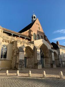 a large stone building with a clock tower on top at Studio indépendant avec mezzanine in Provins