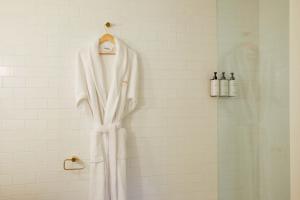 La salle de bains est pourvue d'une douche et d'un peignoir blanc. dans l'établissement Faraway Martha's Vineyard, à Edgartown