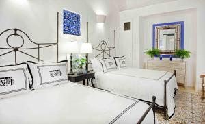 a bedroom with two beds and a mirror at Casas del XVI in Santo Domingo