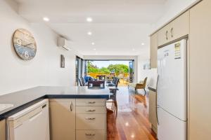 a kitchen with white appliances and a dining room at Winara Winner - Waikanae Holiday Home in Waikanae