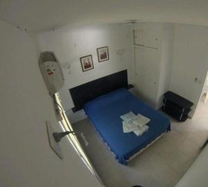 małą sypialnię z niebieskim łóżkiem w pokoju w obiekcie Palmares del Paso w mieście Paso de la Patria