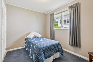懷卡奈的住宿－Winara Winner - Waikanae Holiday Home，一间卧室设有一张床和一个窗口