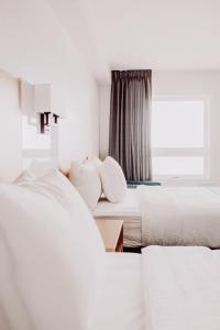 Voodi või voodid majutusasutuse La Place Rendez-Vous Hotel toas