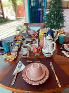 巴拉大的住宿－Amoreira Pousada em Barra Grande Piaui，木桌,上面放有盘子和碗的食物