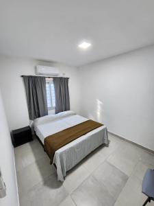 a bedroom with a bed in a white room at BAHIA de los PESCADORES in Paso de la Patria