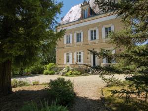 un grand bâtiment en briques avec un toit recouvert de neige dans l'établissement Le Petit Chateau, à Brouchaud