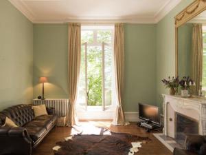 sala de estar con sofá y chimenea en Le Petit Chateau, en Brouchaud