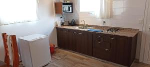 a small kitchen with a sink and a refrigerator at Apart Azul Calafate in El Calafate