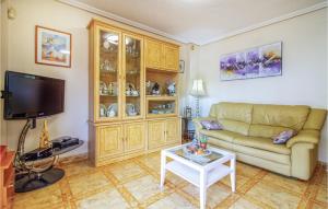 a living room with a couch and a table at Stunning Apartment In Orihuela Costa With Outdoor Swimming Pool in Playas de Orihuela