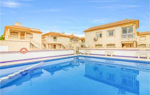 a swimming pool in front of some buildings at Stunning Apartment In Orihuela Costa With Outdoor Swimming Pool in Playas de Orihuela