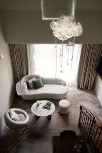 a living room with a white couch and a table at The Playford Adelaide - MGallery in Adelaide