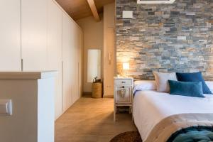 a bedroom with a bed and a brick wall at Casa 20 minutos de Barcelona y WIFI alta capacidad in Sant Cugat del Vallès