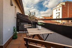 een klein balkon met een houten tafel en stoelen bij Casa 20 minutos de Barcelona y WIFI alta capacidad in Sant Cugat del Vallès