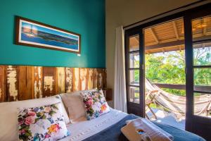a bedroom with a bed and a window at Pousada Flor de Lotus in Praia do Rosa
